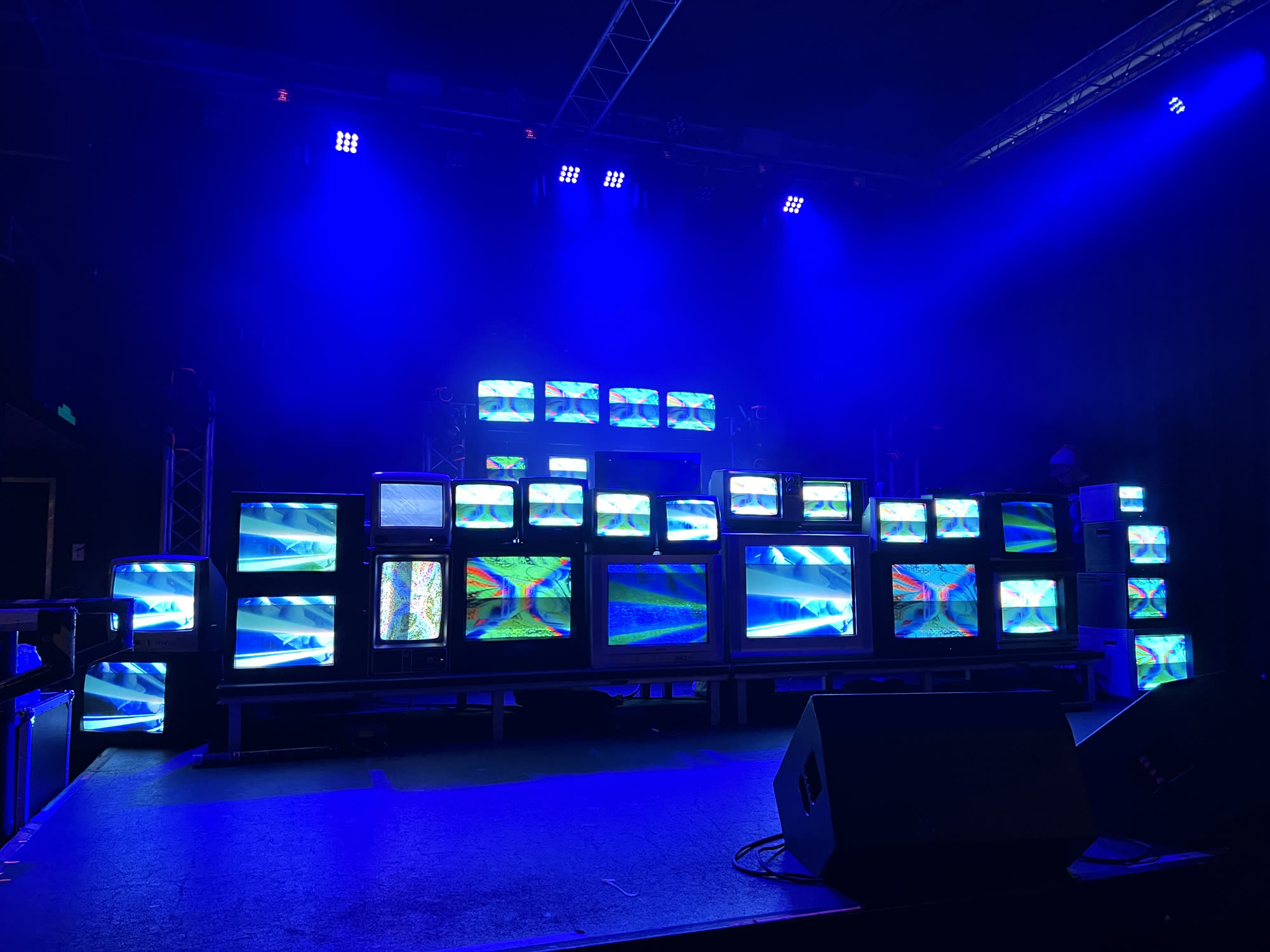 A stage wall of stacked CRT televisions showing generative video